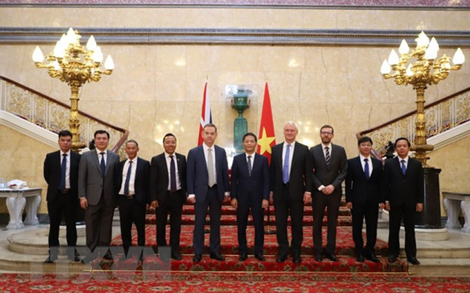 El miembro del Buró Político y jefe de la Comisión de Asuntos Económicos del Comité Central del Partido Comunista de Vietnam (PCV), Tran Tuan Anh, y funcionarios británicos.(Fotografía: VNA)