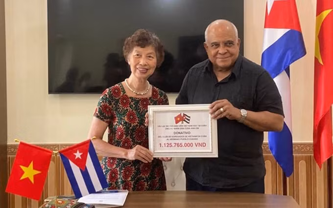 La presidenta del Club de exestudiantes vietnamitas en Cuba, Tran Thanh Dong entregó simbólicamente una donación de 48 mil dólares al embajador cubano en Vietnam, Orlando Nicolás Hernández Guillén. (Fotografía: VNA)