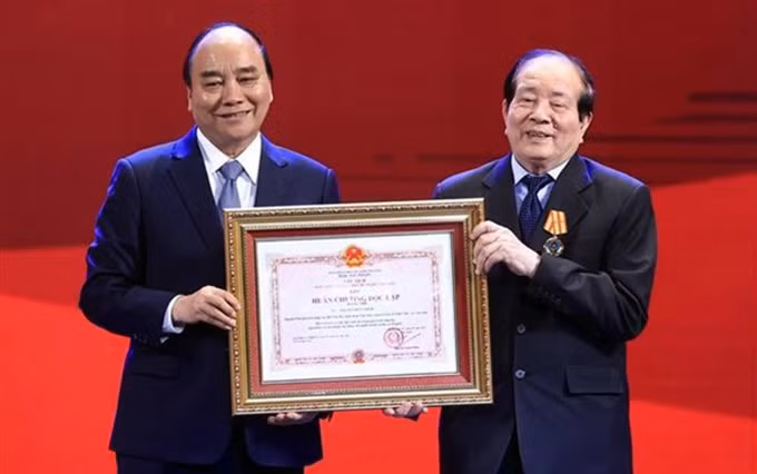 El presidente de Vietnam, Nguyen Xuan Phuc, entrega la Orden de Independencia de segunda clase al poeta Huu Thinh. (Foto: VNA)