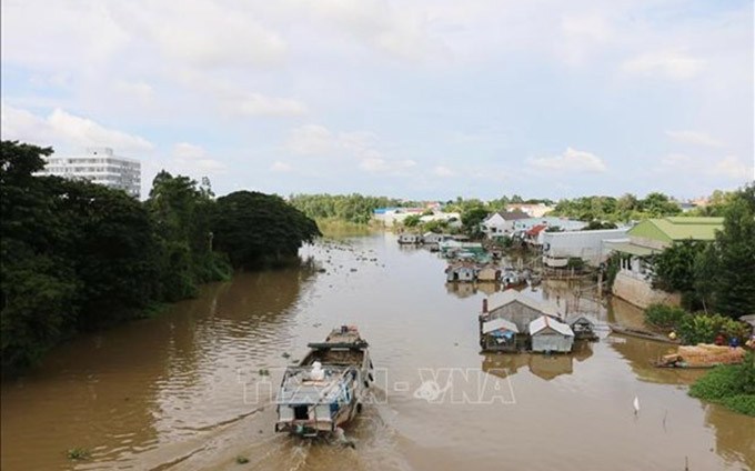Trabajdores vietnamitas cruzan el río para regresar al país. (Fotografía: VNA)