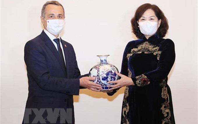 La gobernadora del Banco Estatal de Vietnam, Nguyen Thi Hong, otorga un obsequio al vicepresidente y ministro de Relaciones Exteriores de Suiza, Ignazio Cassis. (Fotografía: VNA)