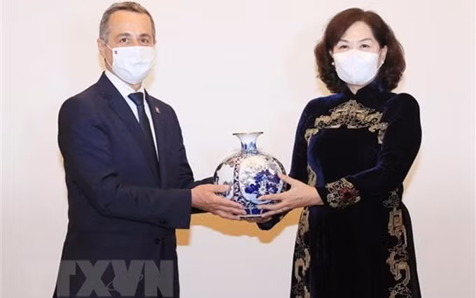 La gobernadora del Banco Estatal de Vietnam, Nguyen Thi Hong, otorga un obsequio al vicepresidente y ministro de Relaciones Exteriores de Suiza, Ignazio Cassis. (Fotografía: VNA)