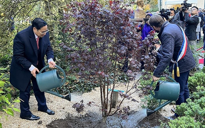 Premier vietnamita Pham Minh Chinh y el acalde Patrice Bessac plantan árboles conmemorativos.