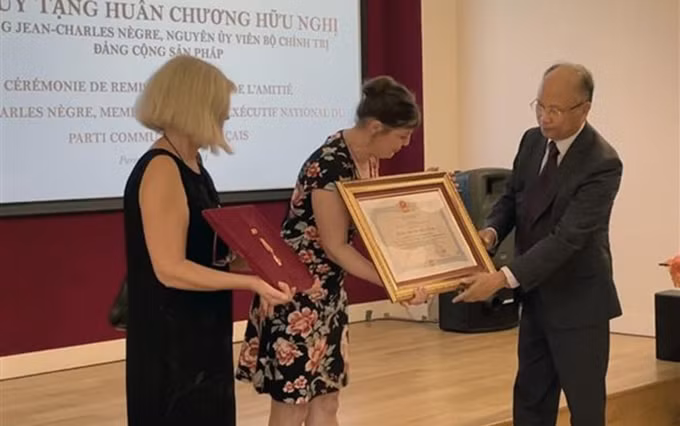 El embajador de Vietnam en Francia, Dinh Toan Thang, entrega la Medalla de Amistad al representante de la familia del Jean-Charles Negre. (Fotografía: VNA)