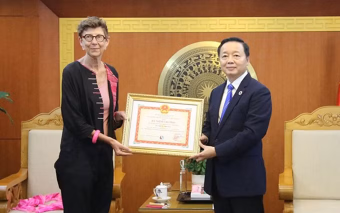 El ministro de Recursos Naturales y Medio Ambiente, Tran Hong Ha, entrega la medalla a la embajadora de Noruega, Grete Lochen. (Fotografía: VNA) 