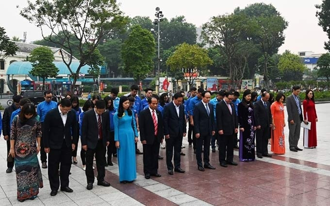 Los delegados colocan flores conmemorativas en el monumento de V.I. Lenin. (Fotografía: nhandan.com.vn)