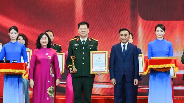 Tran Cam Tu, miembro permanente del Secretariado del Comité Central del PCV, y Bui Thi Minh Hoai, presidenta del Comité Central del Frente de la Patria de Vietnam, entregan los premios A a los autores y grupos de autores galardonados. (Foto: DUY LINH)