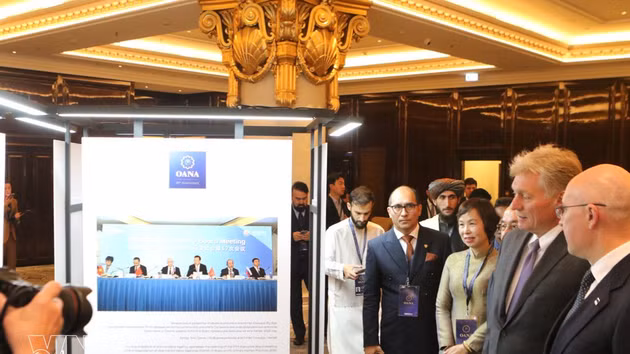 La directora general de la VNA, Vu Viet Trang; el secretario de prensa del Kremlin, Dmitry Peskov; el director general de TASS, Andrey Kondrashov, y otros delegados contemplan las fotografías en la exposición. (Foto: VNA)