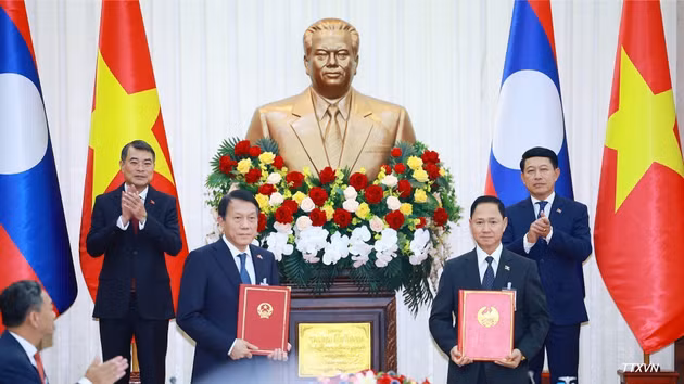 Los primeros ministros Le Minh Hung y Saleumxay Kommasith presencian el intercambio del acta de entrega del sistema de gestión de la población y de identificación ciudadana en Laos entre los ministerios de Seguridad Pública de ambos países. (Foto: DUONG GIANG/VNA)