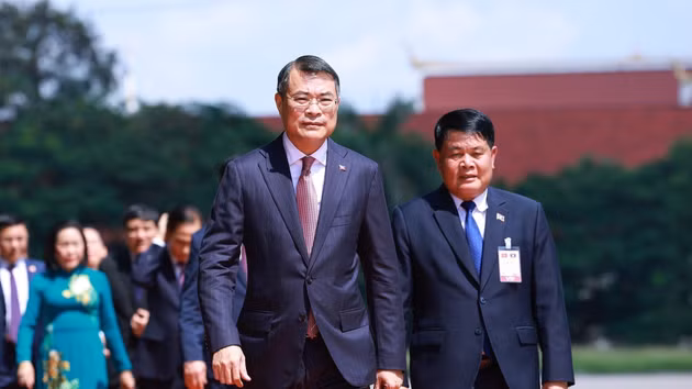El jefe del Gobierno vietnamita y su comitiva llegan al Monumento a los Mártires Desconocidos de Laos para depositar una ofrenda floral. (Foto: VNA)