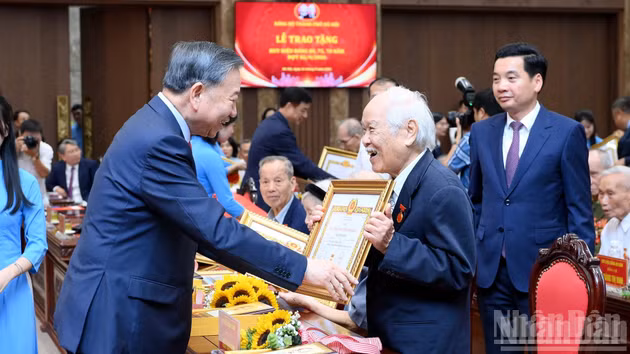 El secretario general del Partido Comunista y presidente de Vietnam, To Lam, entrega a un merecedor la insignia de 80 años de militancia.
