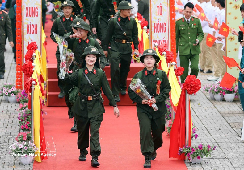 Fieles a la tradición y con plena lealtad al Partido, al Estado y al pueblo, jóvenes vietnamitas se alistan con disposición para cumplir sus misiones. En la imagen: Dos reclutas entre los 470 nuevos soldados parten con entusiasmo desde el punto de alistamiento en Gia Lam (marzo de 2026). (Foto: VNA)
