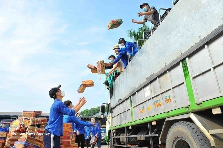 Jóvenes de Hanoi reciben y distribuyen suministros esenciales hacia zonas confinadas, áreas de cuarentena y personas vulnerables afectadas por la pandemia de la COVID-19 (septiembre de 2021). (Foto: VNA)