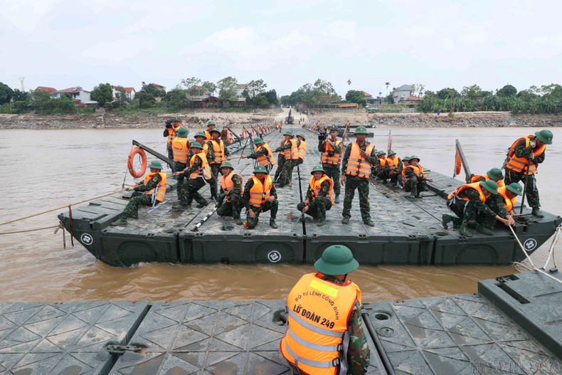 Las fuerzas de ingenieros de la Brigada 249 culminan el ensamblaje del puente flotante para facilitar el cruce del río a la población, tras el colapso del antiguo puente Phong Chau por las lluvias e inundaciones. (Foto: VNA)