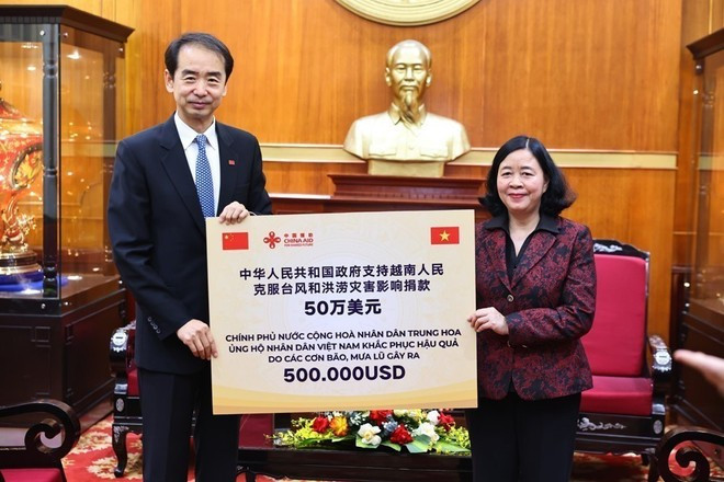 La presidenta del Comité Central del Frente de la Patria de Vietnam (FPV), Bui Thi Minh Hoai, recibe una donación de asistencia financiera de 500.000 dólares del Gobierno chino para la población de las provincias recientemente afectadas por desastres naturales (Foto: VNA)