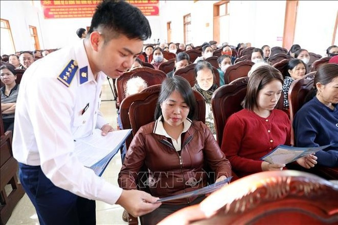 Entrega de folletos sobre la lucha contra IUU durante el programa. (Foto: VNA)