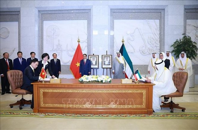 El primer ministro de Vietnam, Pham Minh Chinh, y su homólogo kuwaití, Sheikh Ahmad Al-Abdullah Al-Sabah en la firma de un protocolo que modifica el acuerdo de exención de visados para pasaportes diplomáticos y oficiales. (Foto: VNA)