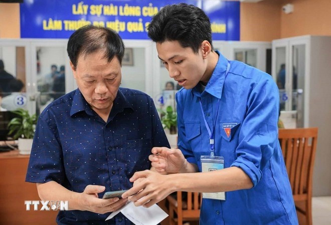Los miembros de la Unión de Jóvenes Comunistas Ho Chi Minh orientan a las personas sobre cómo utilizar y declarar servicios públicos en línea en teléfonos inteligentes. (Foto: VNA) Los miembros de la Unión de Jóvenes Comunistas Ho Chi Minh orientan a las personas sobre cómo utilizar y declarar servicios públicos en línea en teléfonos inteligentes. (Foto: VNA)
