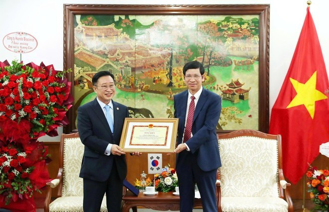 El viceministro Ho An Phong entregó el certificado al mérito del Ministro de Cultura, Deportes y Turismo al Embajador de Turismo de Vietnam en Corea del Sur, y Xuong Can (Lee Chang Kun), en reconocimiento a sus contribuciones. (Foto: VNA) El viceministro Ho An Phong entregó el certificado al mérito del Ministro de Cultura, Deportes y Turismo al Embajador de Turismo de Vietnam en Corea del Sur, y Xuong Can (Lee Chang Kun), en reconocimiento a sus contribuciones. (Foto: VNA)