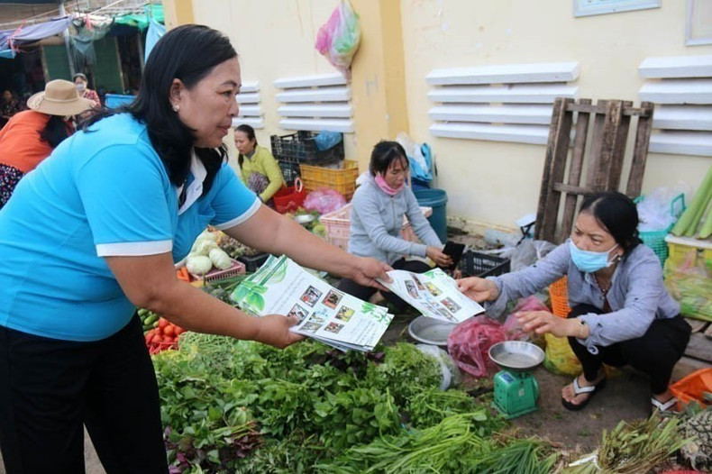 En el mercado de Tam Thanh, provincia de Binh Thuan, se distribuyen folletos y se realizan actividades de divulgación para concienciar a compradores y vendedores sobre la protección del medio ambiente y la lucha contra los residuos plásticos. (Foto: VNA) anh-6-2.jpg