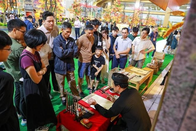 Los turistas demuestran gran interés en los puestos de artesanía tradicional. (Foto: VNA) Los turistas demuestran gran interés en los puestos de artesanía tradicional. (Foto: VNA)