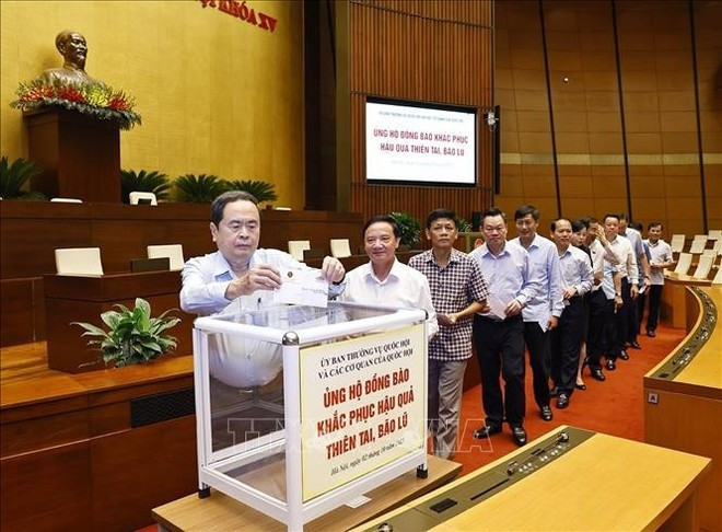 Los miembros de la Asamblea Nacional realizan una contribución solidaria a favor de las personas afectadas por el tifón Bualoi. (Foto: VNA) Los miembros de la Asamblea Nacional realizan una contribución solidaria a favor de las personas afectadas por el tifón Bualoi. (Foto: VNA)