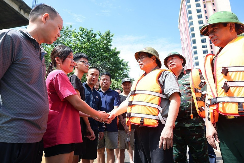 El primer ministro Pham Minh Chinh visita a los compatriotas afectados por las inundaciones en el barrio de Phan Dinh Phung, de la provincia de Thai Nguyen. (Foto: VNA)