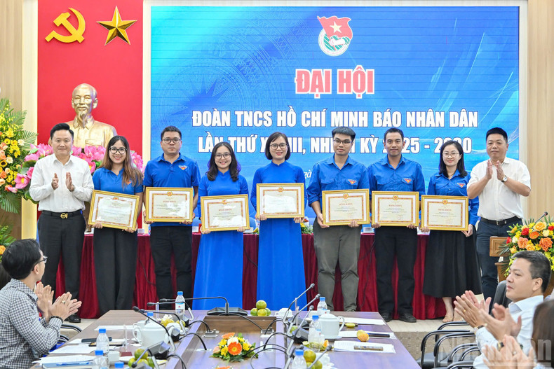 Que Dinh Nguyen y Phan Van Hung, ambos redactores subjefes del periódico Nhan Dan, entregan el certificado de mérito del presidente-editor del diario al Comité de la UJCHCM en el periódico Nhan Dan del XXVIII mandato.