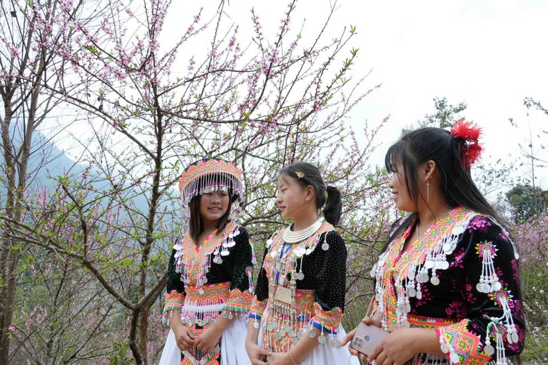Las muchachas de la etnia Hmong con llamativos trajes tradicionales se divierten en la aldea turística Sin Suoi Ho. (Foto: VNA)
