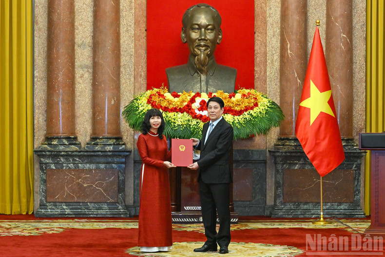 El presidente Luong Cuong entrega la decisión de nombramiento como embajadora extraordinaria y plenipotenciaria a Pham Thi Kim Hoa.