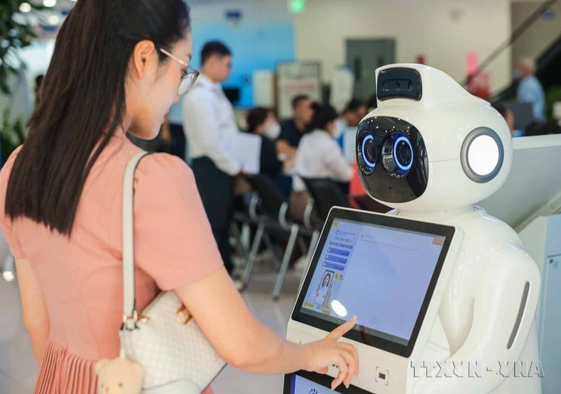 La ciencia, la tecnología, la innovación y la transformación digital continúan siendo identificadas como motores del desarrollo. En la foto: Un robot recepcionista ayuda con los trámites, consultas de información y orientación a los mostradores, aliviando la carga del personal humano. (Foto: VNA)