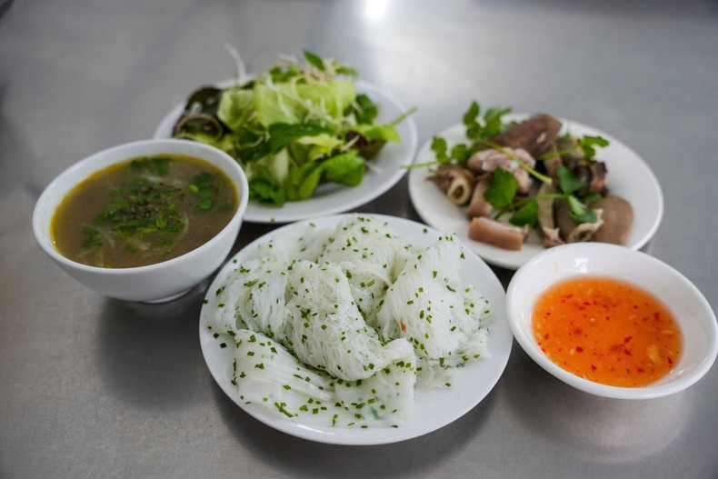 Una buena tanda debe tener hebras tan finas como escarbadientes de bambú, los trozos no deben estar separados ni apelmazados, no deben desmenuzarse al comer, y se debe poder saborear la dulzura de la harina de arroz y la riqueza del aceite de coco. Se sirve con vísceras de cerdo, como corazón, hígado, riñones, etc., acompañadas de hierbas y salsa de pescado con tamarindo. (Foto: VNA)