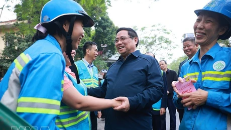 El primer ministro Pham Minh Chinh y trabajadores ambientales. (Foto: VNA)