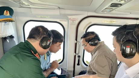 El primer ministro Pham Minh Chinh (segundo desde la derecha) realiza una inspección aérea desde un helicóptero de la autopista Ca Mau-Dat Mui, la carretera que conduce a Hon Khoai y el puerto de doble uso de Hon Khoai. (Foto: VNA)