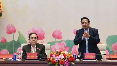 El secretario del Comité del Partido Comunista de Vietnam en el Gobierno y primer ministro, Pham Minh Chinh (de pie), y el secretario del Comité del Partido en la Asamblea Nacional y presidente de esta entidad, Tran Thanh Man, conducen la conferencia.