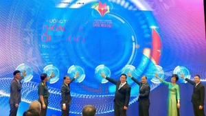Nguyen Trong Nghia, miembro del Buró Político y del Secretariado del Comité Central del PCV, jefe de la Comisión de Propaganda y Movilización de Masas de ese comité y titular del Comité Directivo Central para Información al Exterior, y otros altos funcionarios presionan el botón protocolario para lanzar el galardón. (Fotografía: Nhan Dan)