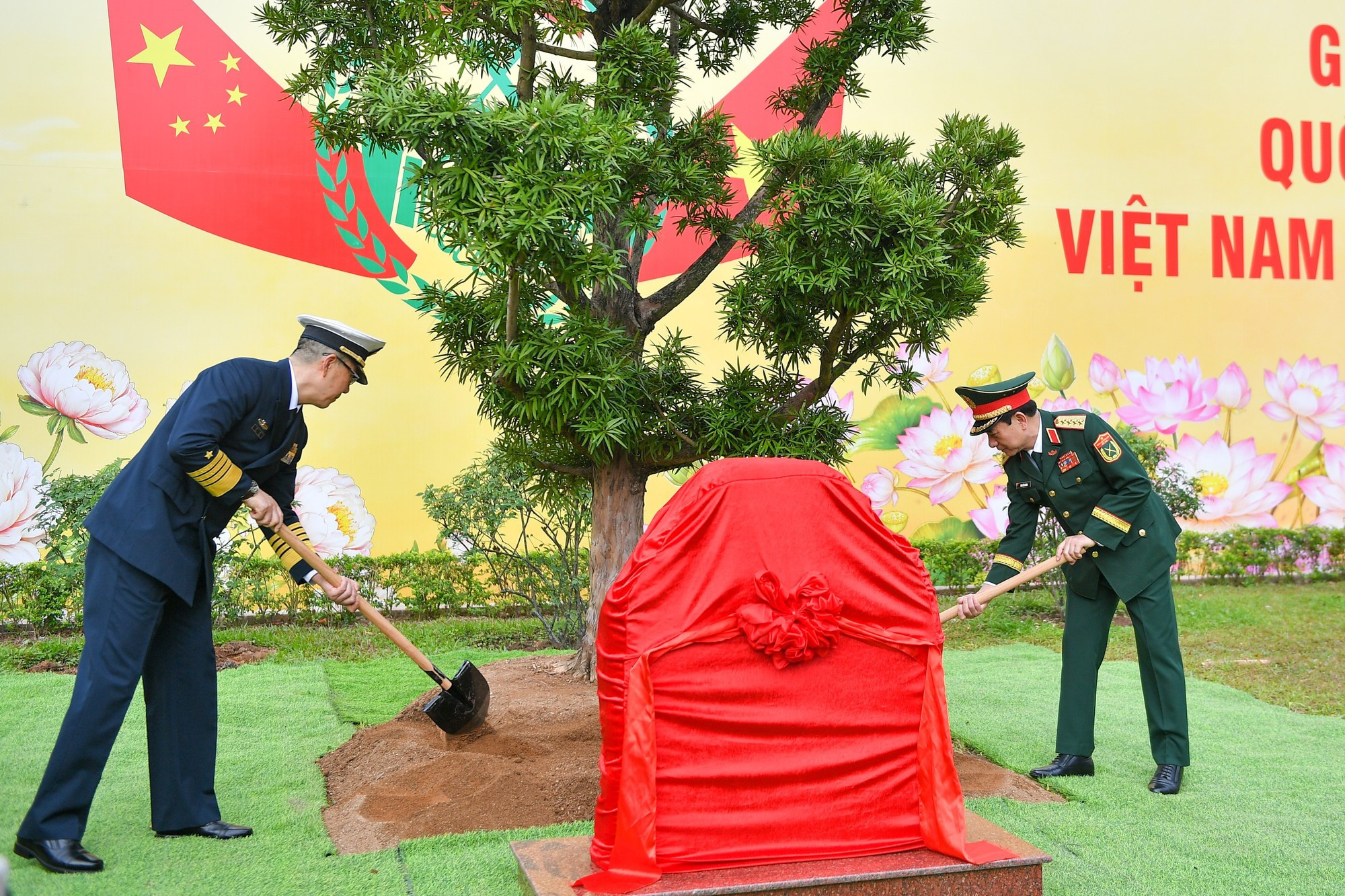 Van Giang y Dong Jun plantan un árbol de amistad en el paso fronterizo internacional de Mong Cai.