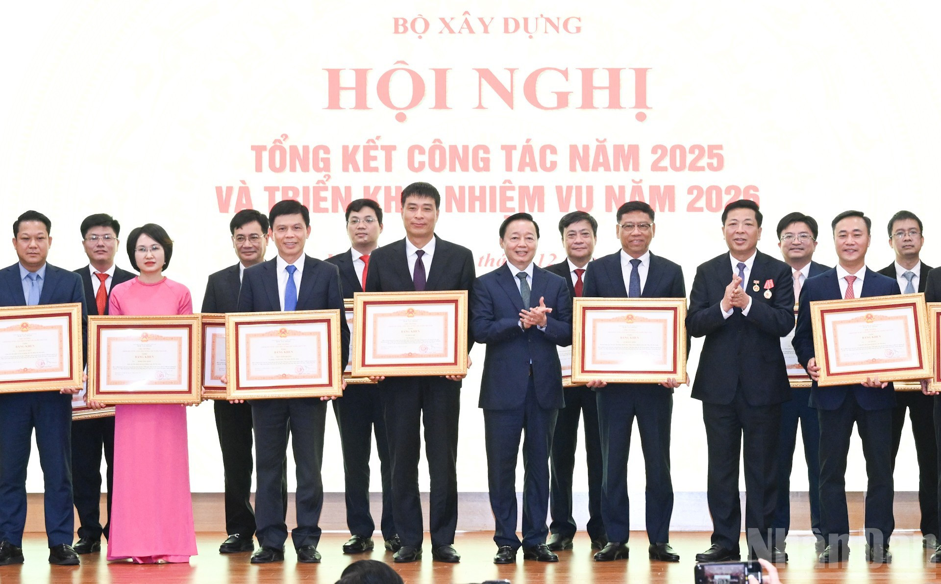 El viceprimer ministro Tran Hong Ha y el ministro de Construcción Tran Hong Minh entregan certificados de mérito del primer ministro a colectivos e individuos.