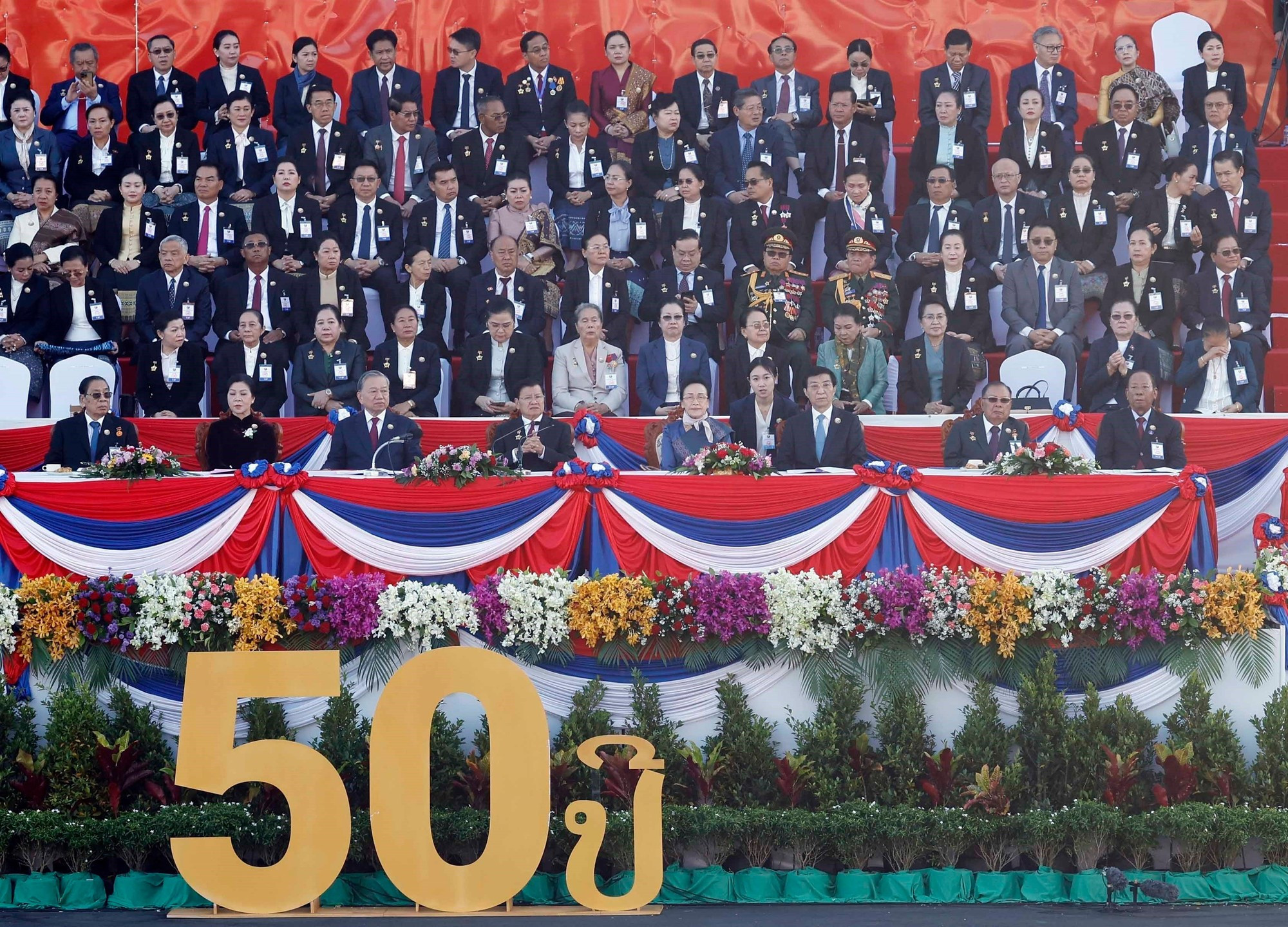 El secretario general del PCV, To Lam, y su esposa asisten a la ceremonia conmemorativa y al desfile militar en celebración del 50º aniversario del Día Nacional de Laos y del 105º aniversario del nacimiento del presidente Kaysone Phomvihane.