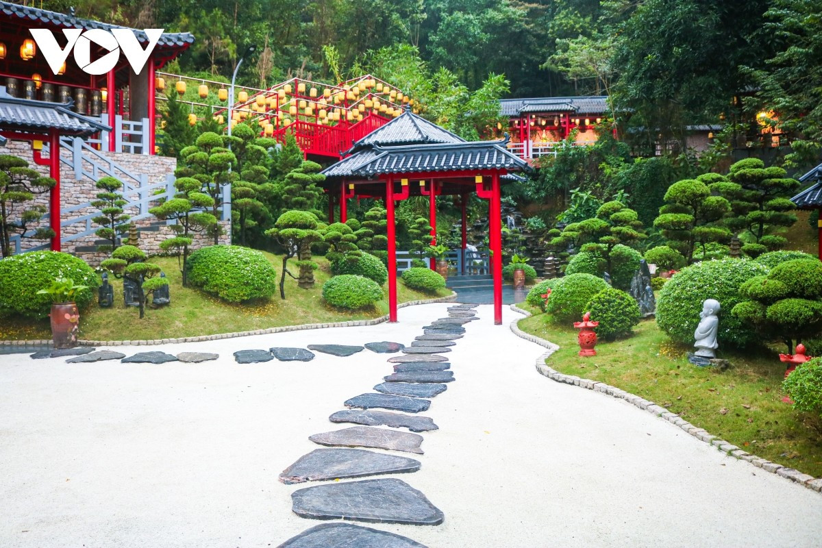 El camino de acceso a la pagoda está cubierto de guijarros blancos, mientras los alrededores de las colinas se visten de un verde intenso de césped japonés entremezclado con pinos.