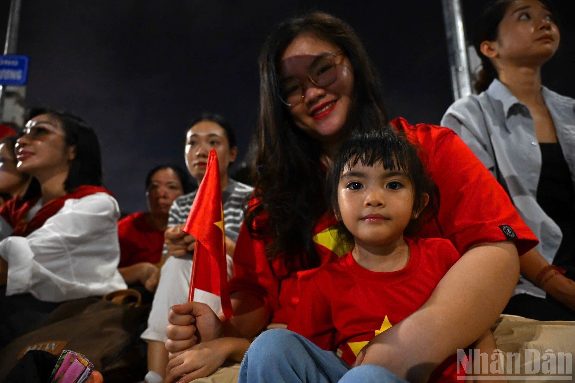 Muchos niños son llevados por sus padres, con la bandera nacional en las manos, observando atentamente el paso de cada formación militar.
