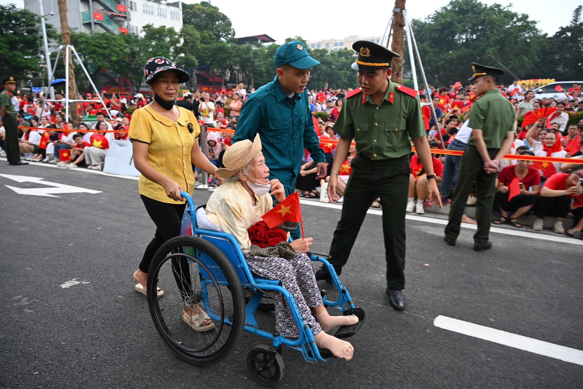 La señora Tran Thi Bich Lien, de 83 años y residente en el barrio de Ba Dinh, es trasladada por las autoridades a un lugar seguro para presenciar el ensayo. La señora Tran Thi Bich Lien, de 83 años y residente en el barrio de Ba Dinh, es trasladada por las autoridades a un lugar seguro para presenciar el ensayo.