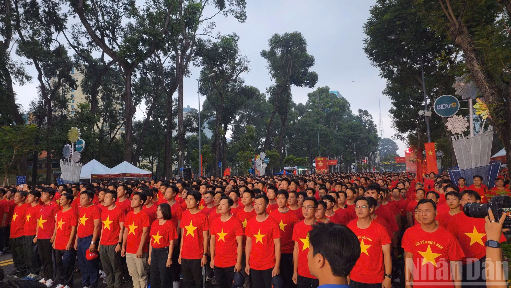 En un ambiente solemne, emotivo y orgulloso, miles de personas se congregan en el Jardín de Flores Ly Thai To para saludar a la bandera y entonar el himno nacional, mientras se celebra simultáneamente la ceremonia de izado de la bandera en la histórica Plaza Ba Dinh.