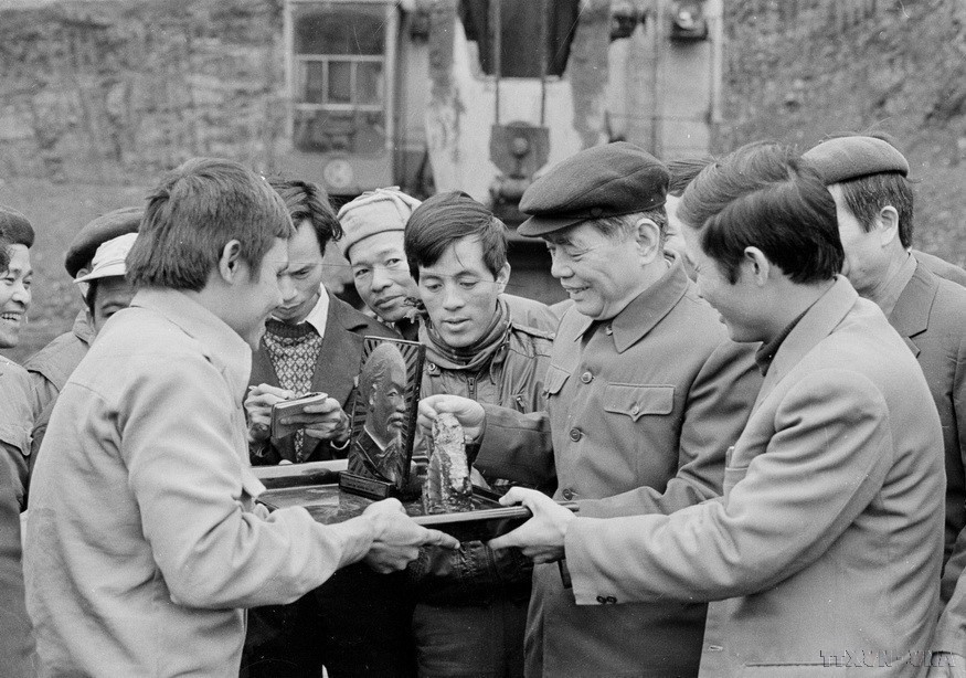Mineros de carbón en la pila 6 (Cam Pha, Quang Ninh) entregan al secretario general Nguyen Van Linh una obra de arte hecha de carbón (1987).