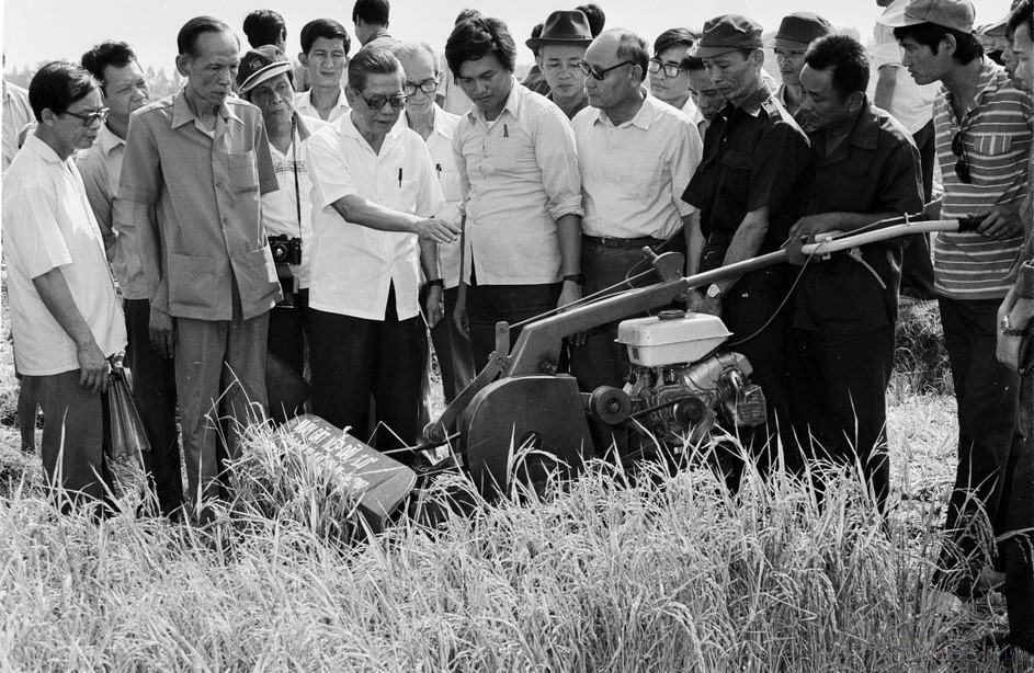 El secretario general Nguyen Van Linh observa la máquina cortadora de arroz de la Cooperativa Phuoc Tu (Long An, 1988).