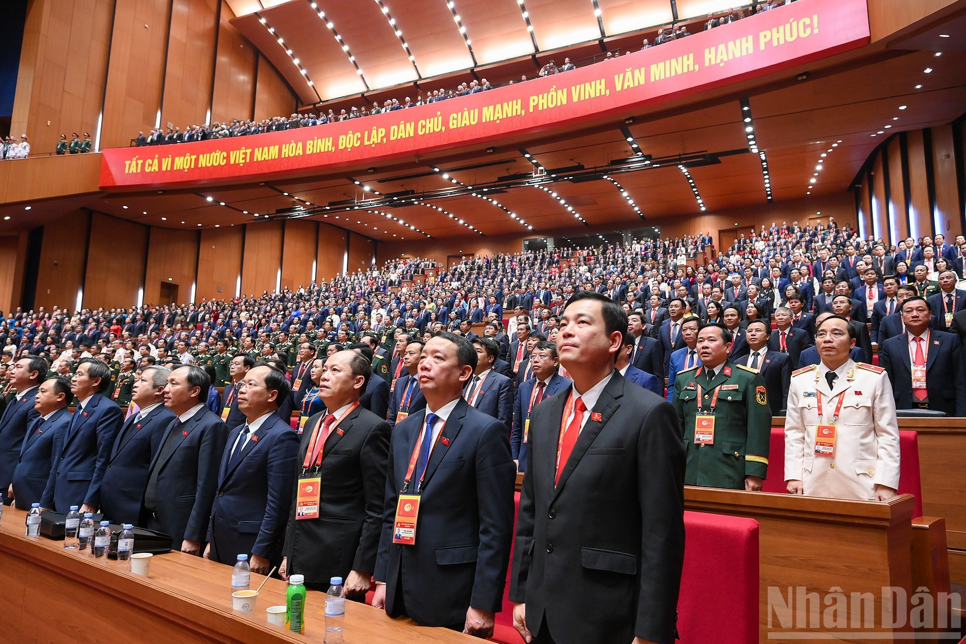 Delegados saludan la bandera nacional en la sesión de clausura.