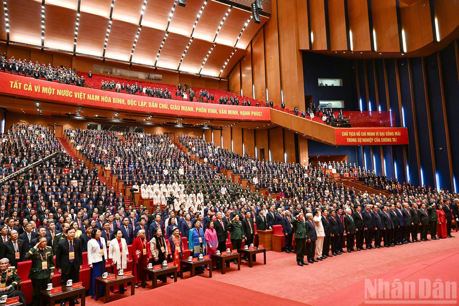 Delegados saludan la bandera nacional en la sesión de clausura.