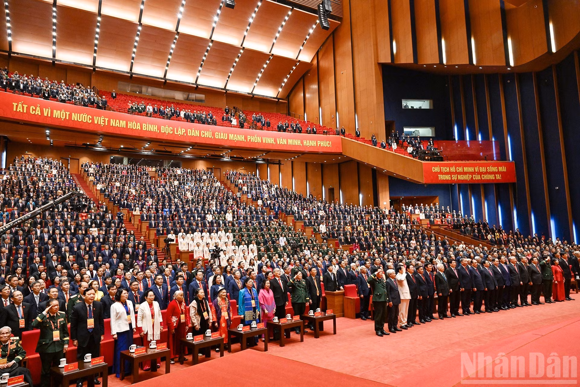 Delegados saludan la bandera nacional en la sesión de clausura.