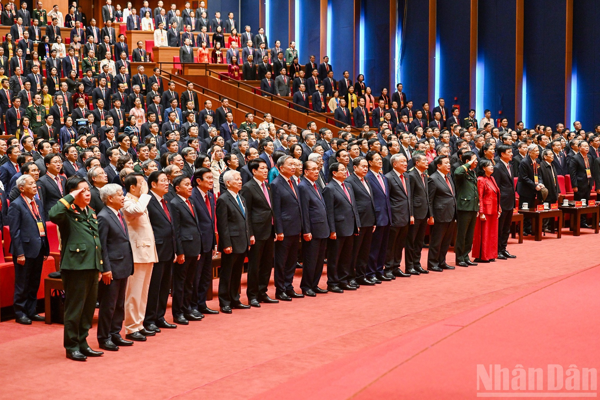 Delegados saludan la bandera nacional en la sesión de clausura.