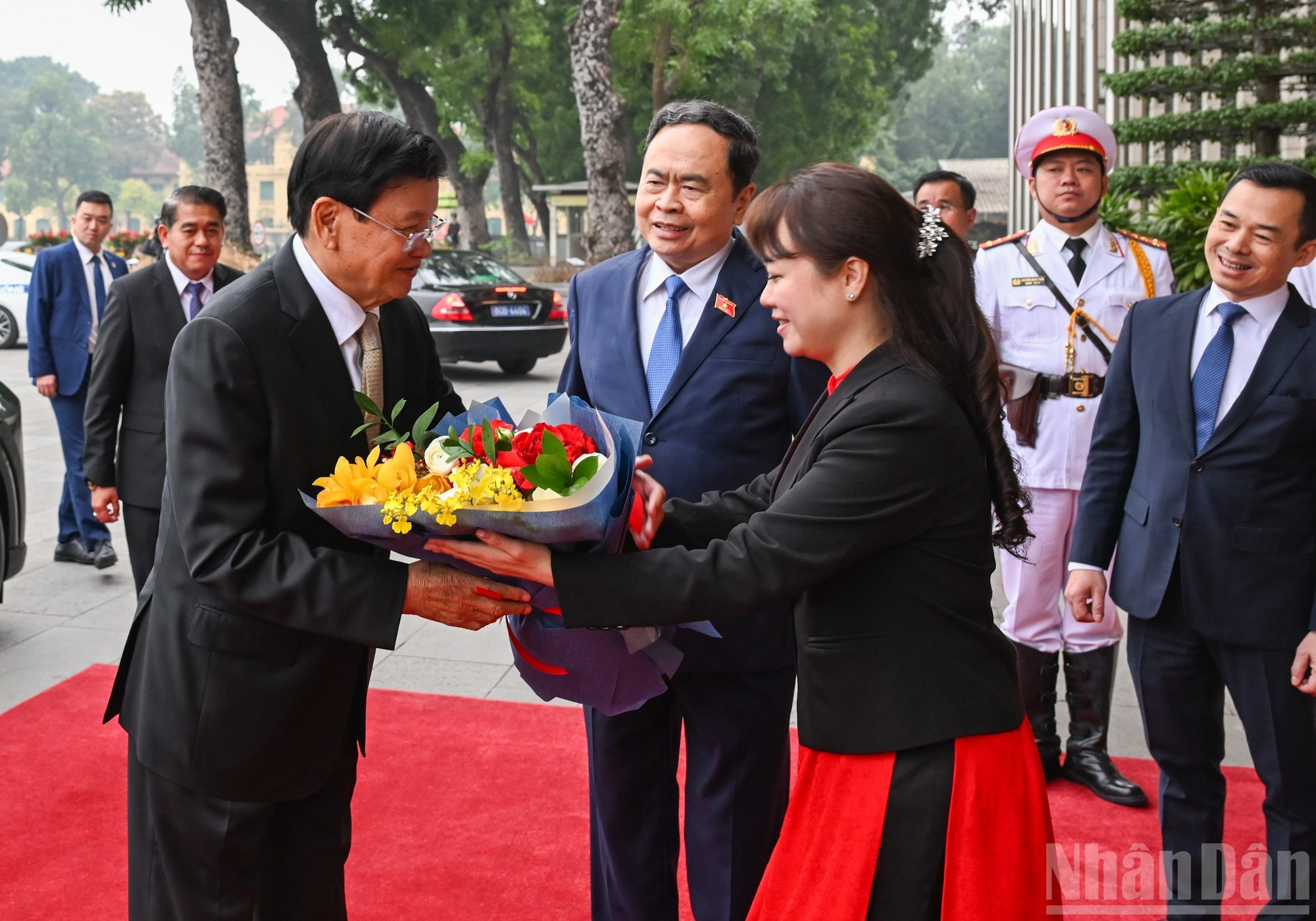 Personal de la Oficina de la Asamblea Nacional entrega flores en bienvenida al visitante laosiano.